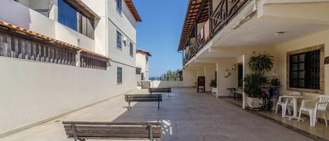 A courtyard with benches, potted plants, and outdoor seating.
