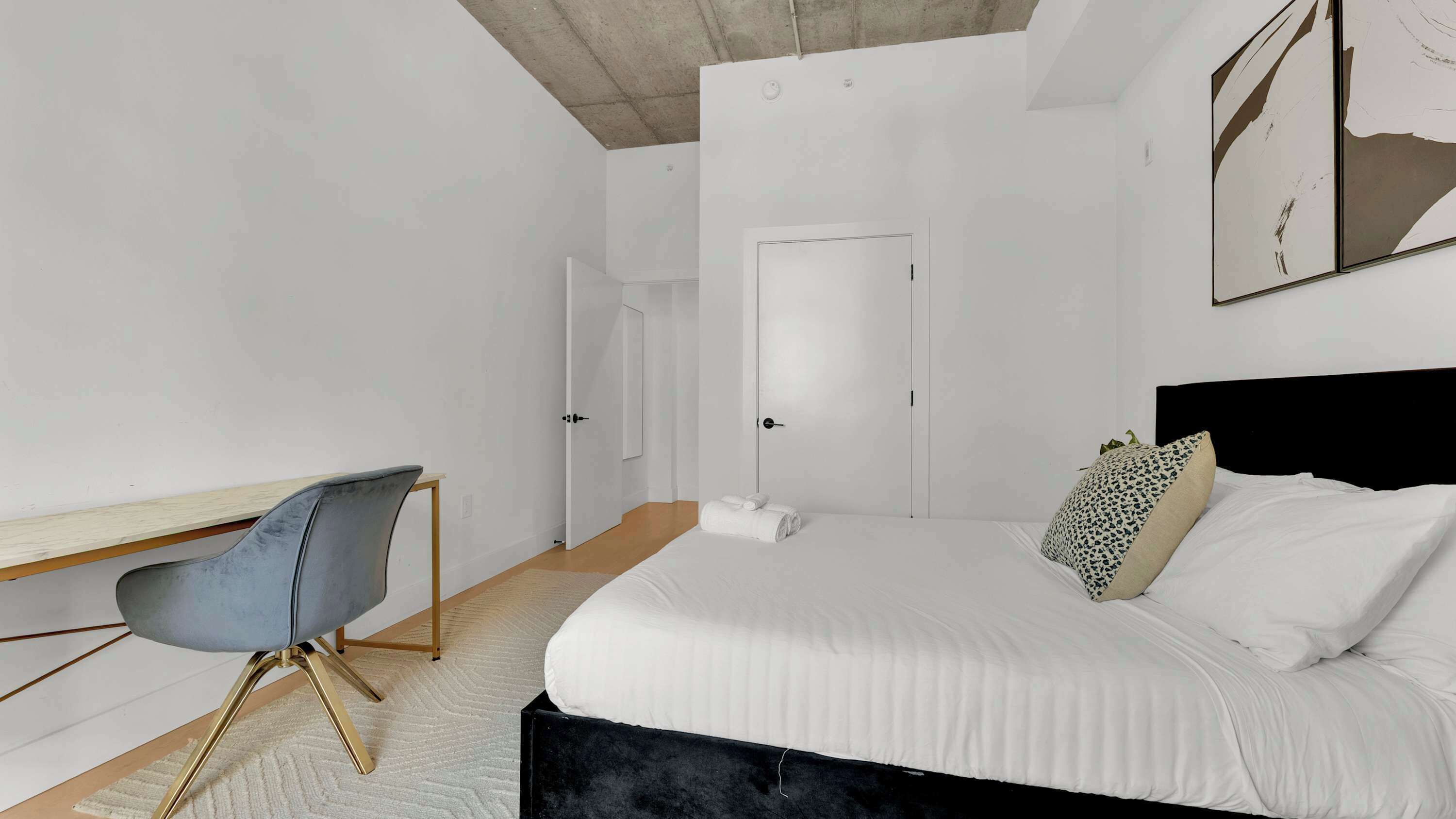 A modern bedroom with a bed, a desk, and a chair.