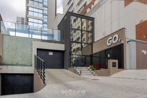 A modern building with a glass facade, a visible entrance, and a sign reading "GO".