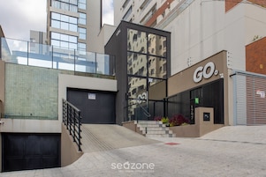 Un edificio moderno con fachada de vidrio, una entrada visible y un letrero que dice 