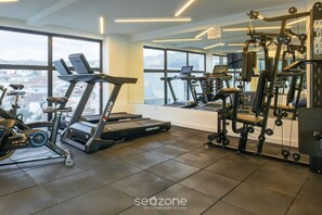 A gym with treadmills, exercise bikes, and weight machines. - Your Complete Stay With Pool and gym in Pocos de Caldas - NGO (Poços de Caldas)