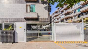 A gated entrance to Ed. Mar Azuleta Costa Dourada, featuring a metal gate and a sign with the property name.