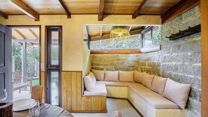 A cozy room with a built-in L-shaped sofa, a wooden coffee table, and a dining table with chairs. - House With Valley View Near the Center - Mrv0001 (Imbituba)