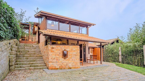 A two-story house with a brick facade, a wooden staircase, and a covered porch. - House With Valley View Near the Center - Mrv0001 (Imbituba)