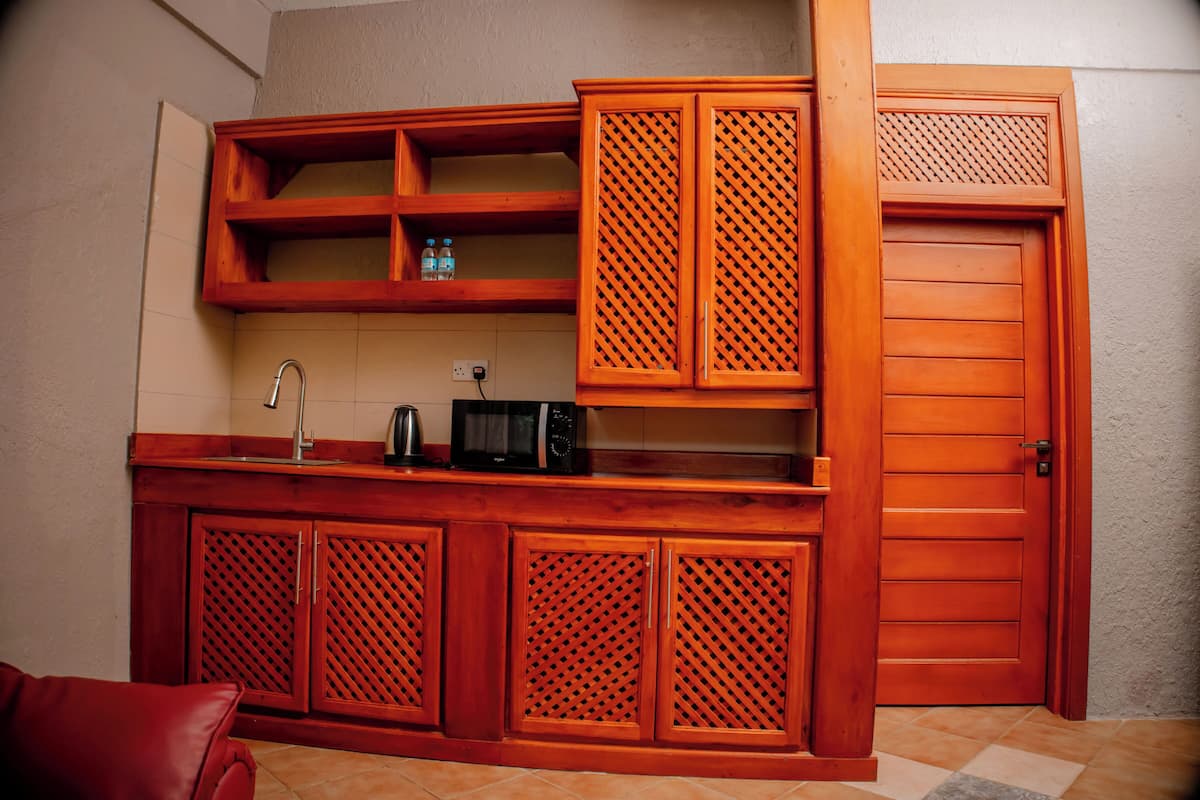 A kitchen with wooden cabinets, a microwave, and a sink.