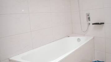 Un baño con bañera, ducha e inodoro.