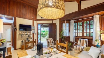 Una sala de estar acogedora con chimenea, sillones a rayas y un televisor.