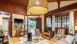 Una sala de estar acogedora con chimenea, sillones a rayas y un televisor.