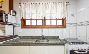 A kitchen with a granite countertop, a stainless steel sink, a stove, and a microwave. - Charming House With BBQ by the sea Mon0099 (Barra Velha)