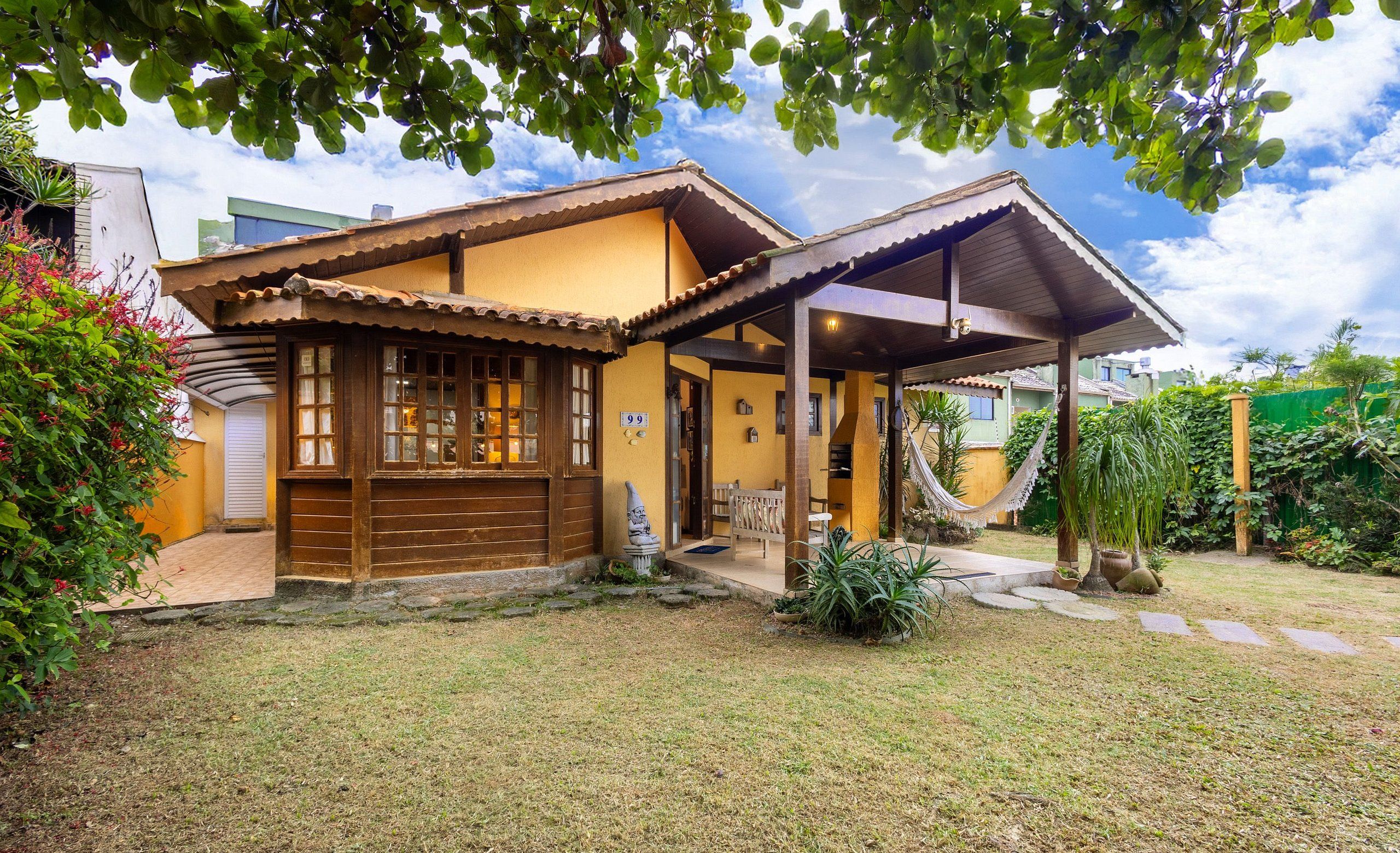 A house with a covered porch, a hammock, and a small garden.
