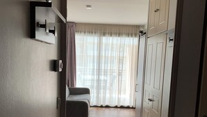Un couloir avec un canapé, une armoire et un plafond orné de motifs ajourés.