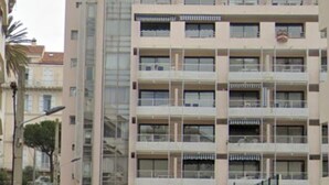 Un immeuble à plusieurs étages doté de balcons, d’une entrée sécurisée et d’un petit jardin.