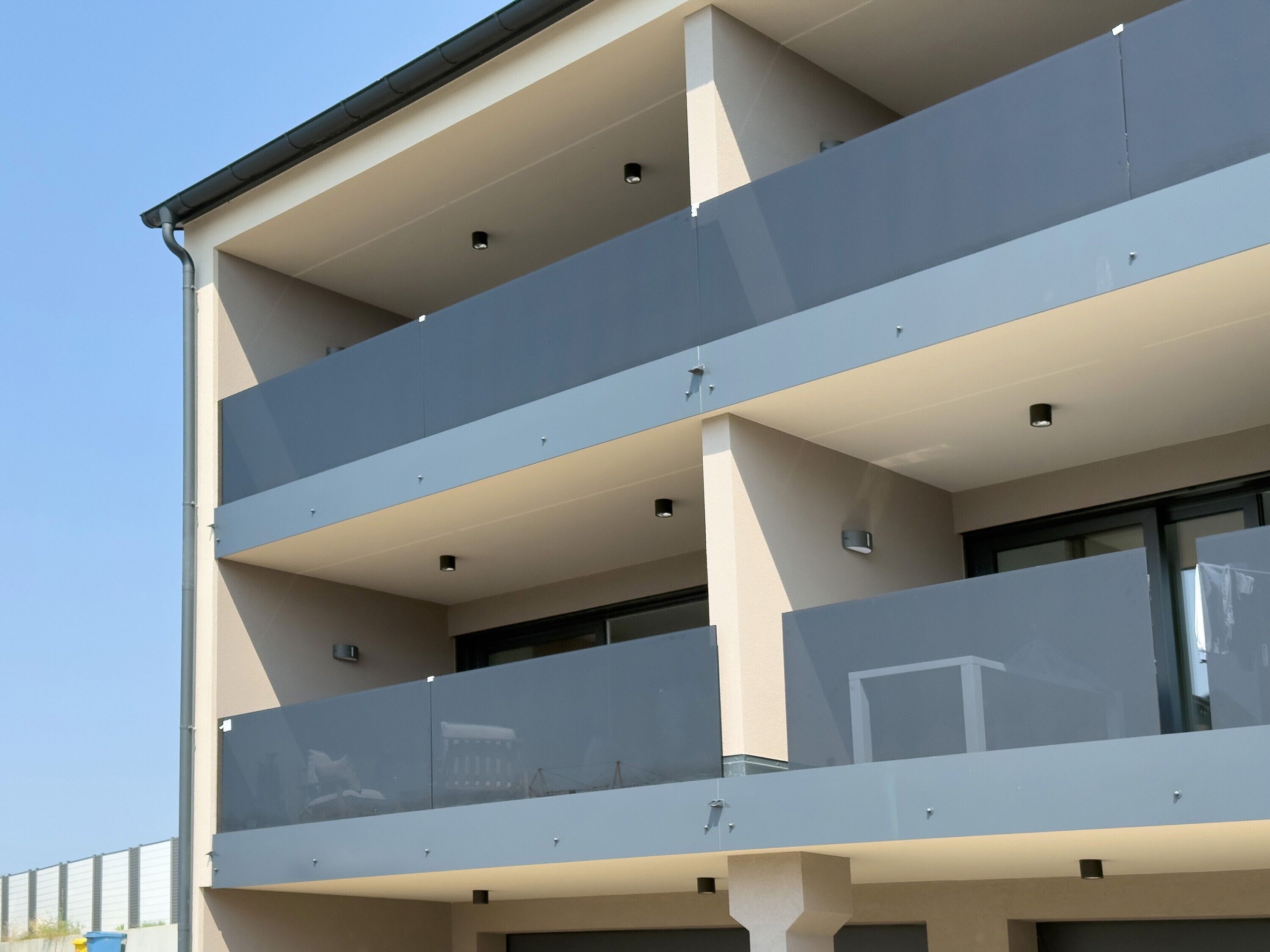 Een meerlaags gebouw met balkons, grote ramen en een modern architectonisch ontwerp.