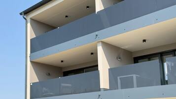 Een meerlaags gebouw met balkons, grote ramen en een modern architectonisch ontwerp.