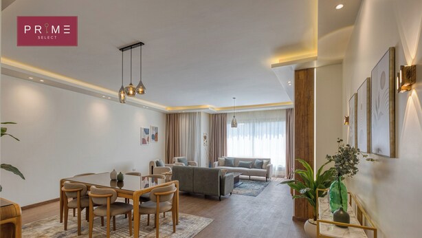 A modern living room with a dining area, a sofa set, and a large window with curtains.