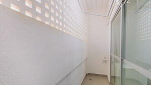 A narrow corridor with a textured white wall, a glass door, and a ceiling with a grid-like pattern. - Fully Equipped Accommodations in the Heart of Brasilia LEC (Sudoeste e Octogonal)