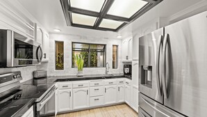 A modern kitchen with a skylight, stainless steel appliances, and white cabinetry. - 25%Off Sep 24-27 Waterfront Great 4 Families -Dock (Oxnard)