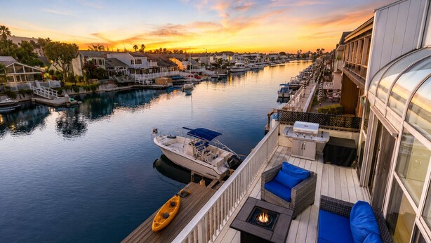 A waterfront balcony with a boat, a kayak, and outdoor seating. - 25%Off Sep 24-27 Waterfront Great 4 Families -Dock (Oxnard)