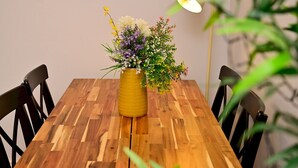 Ein Holztisch mit einer gelben Blumenvase und einer Lampe.