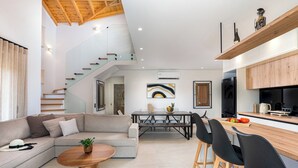 A modern living room with a sofa, coffee table, and a staircase leading to an upper level.
