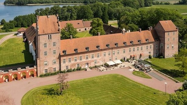 A large, historic building with multiple wings, surrounded by well-maintained lawns and a body of water in the background. - Modern 1-bedroom Apartment for 6 Near Kristianstad (Fjalkinge)