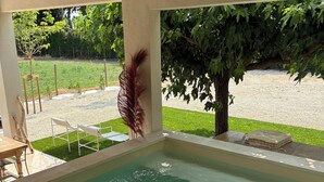 A swimming pool with clear water, surrounded by a patio area with chairs and a table.