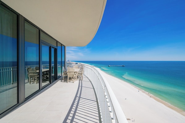 Un balcon avec vue sur une plage et l’océan.