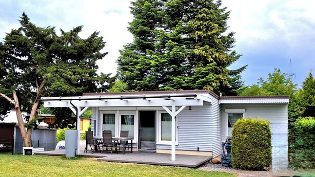 A single-story house with a covered patio, a small deck, and a front door.