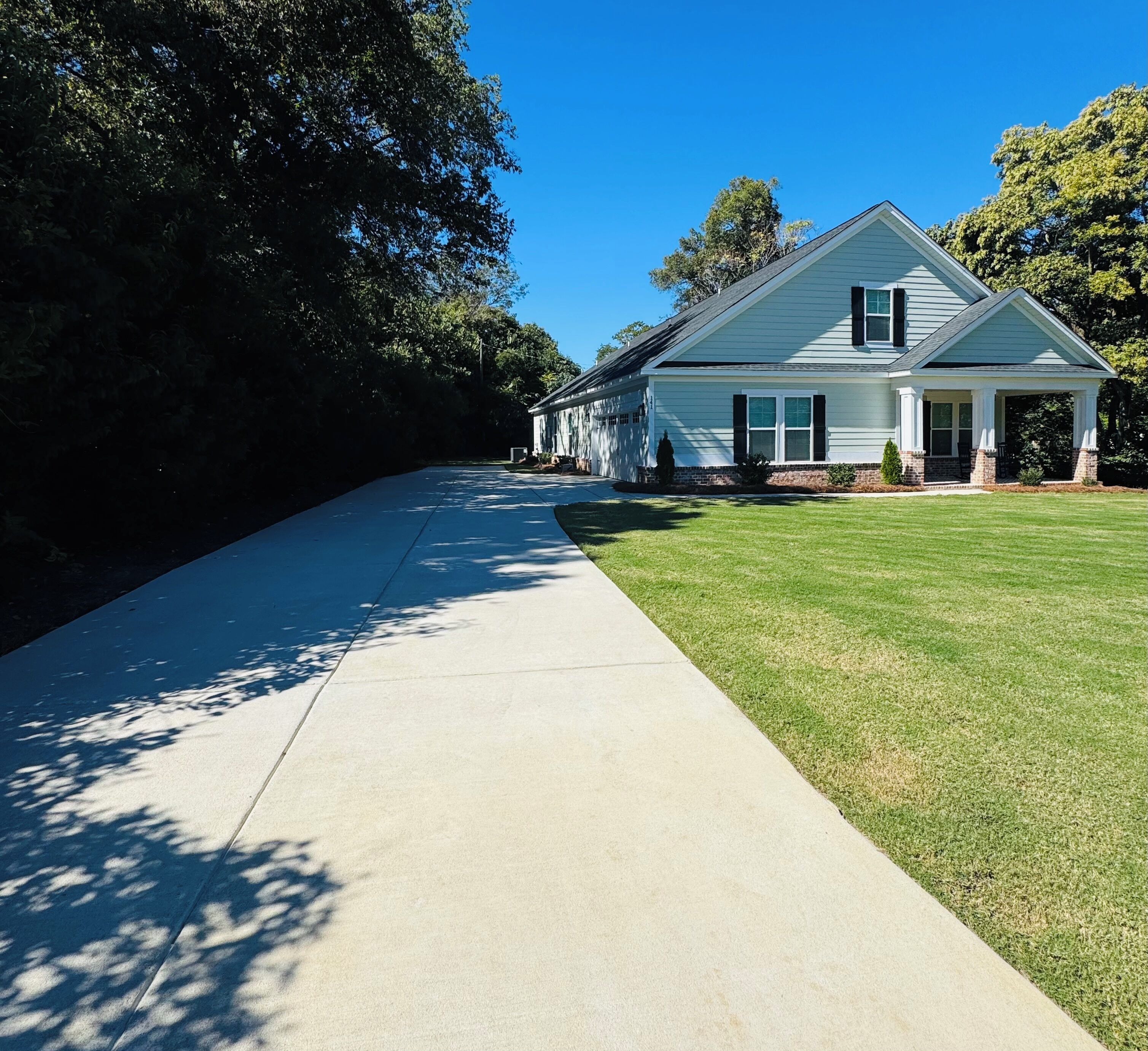A two-story house with a covered porch and a well-maintained lawn.