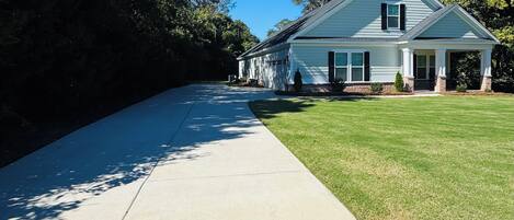 A two-story house with a covered porch and a well-maintained lawn.