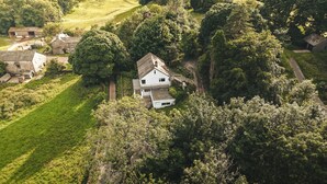An aerial view of a house surrounded by lush greenery and trees. - Tethers End (Windermere)