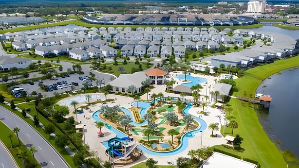 Un complexe hôtelier comprenant plusieurs villas blanches, un espace central avec piscine et un bassin d’eau sinueux, ainsi qu’un port de plaisance.