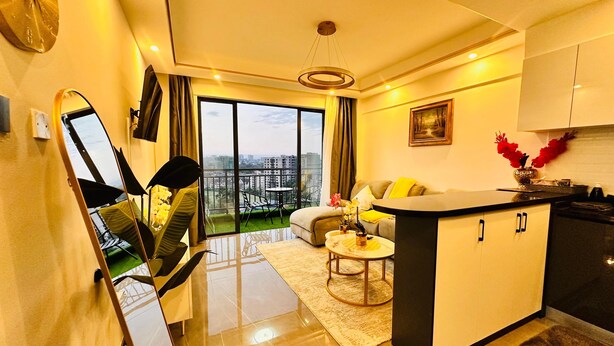 Eine moderne Wohnung mit Küche, Essbereich und einem Balkon mit Blick auf die Stadt.