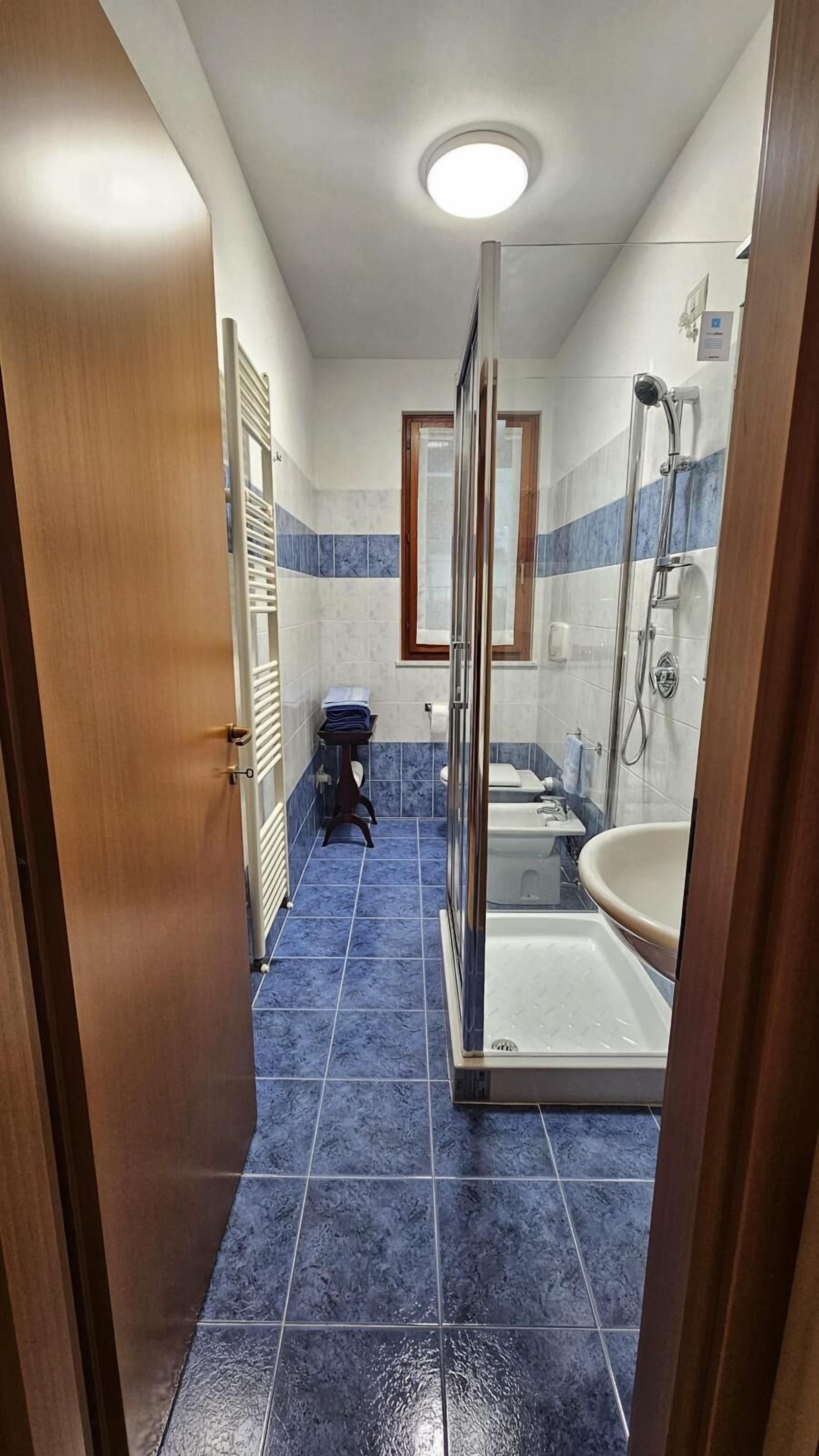A bathroom with a shower, bathtub, and toilet.