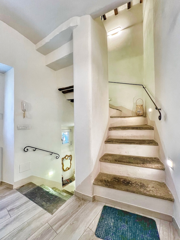 A staircase with wooden steps and metal handrails, leading to an upper floor.