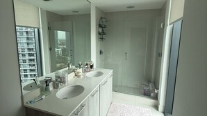 A modern bathroom with a large mirror, two sinks, and a shower area. - Edgawater midtown beautiful 2 bedroom condo available for rent (Miami)