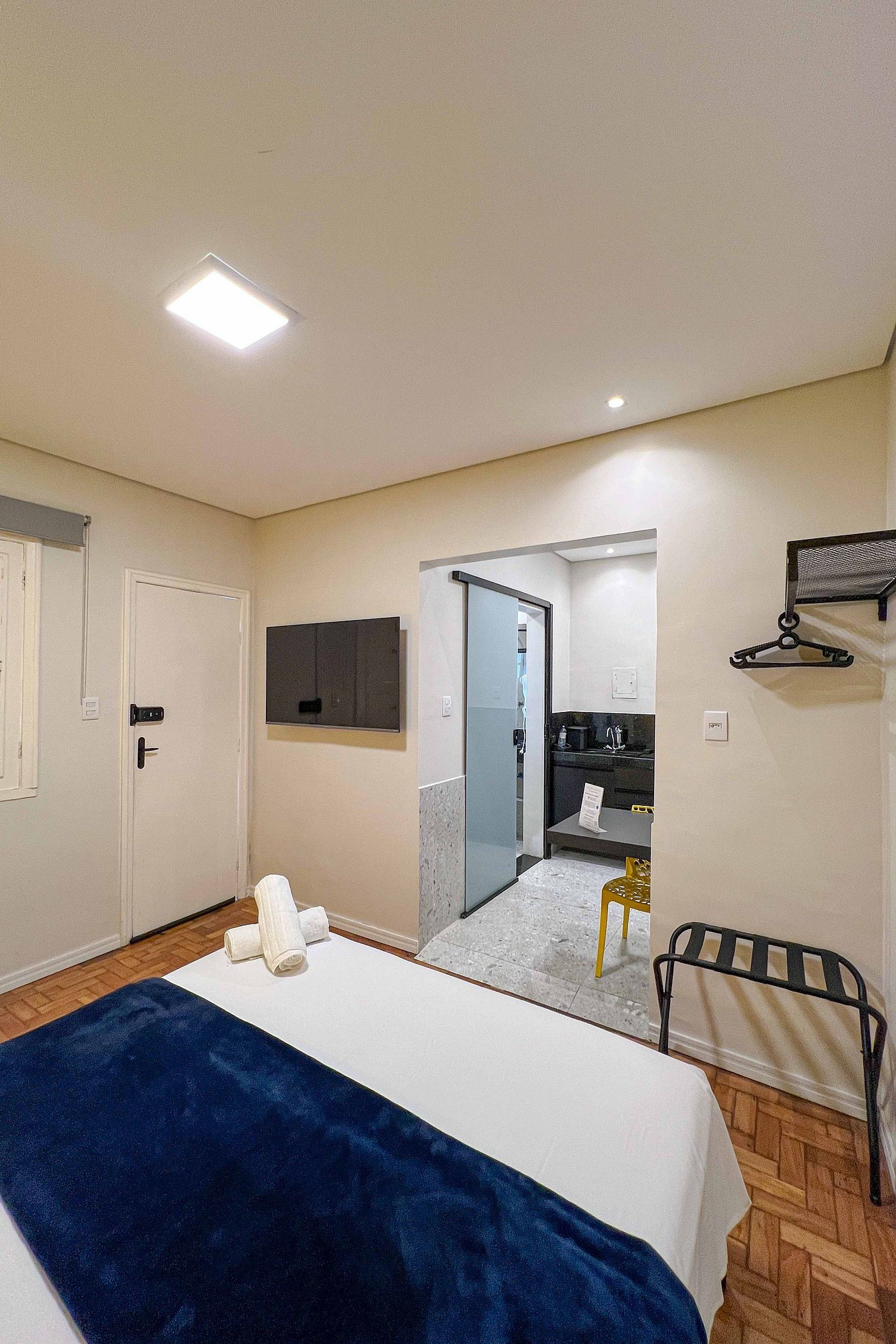 Une chambre à coucher avec un lit, un bureau, une chaise et un miroir.
