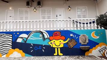 Un edificio con techo de tejas y un mural en la pared que representa un personaje de caricatura.