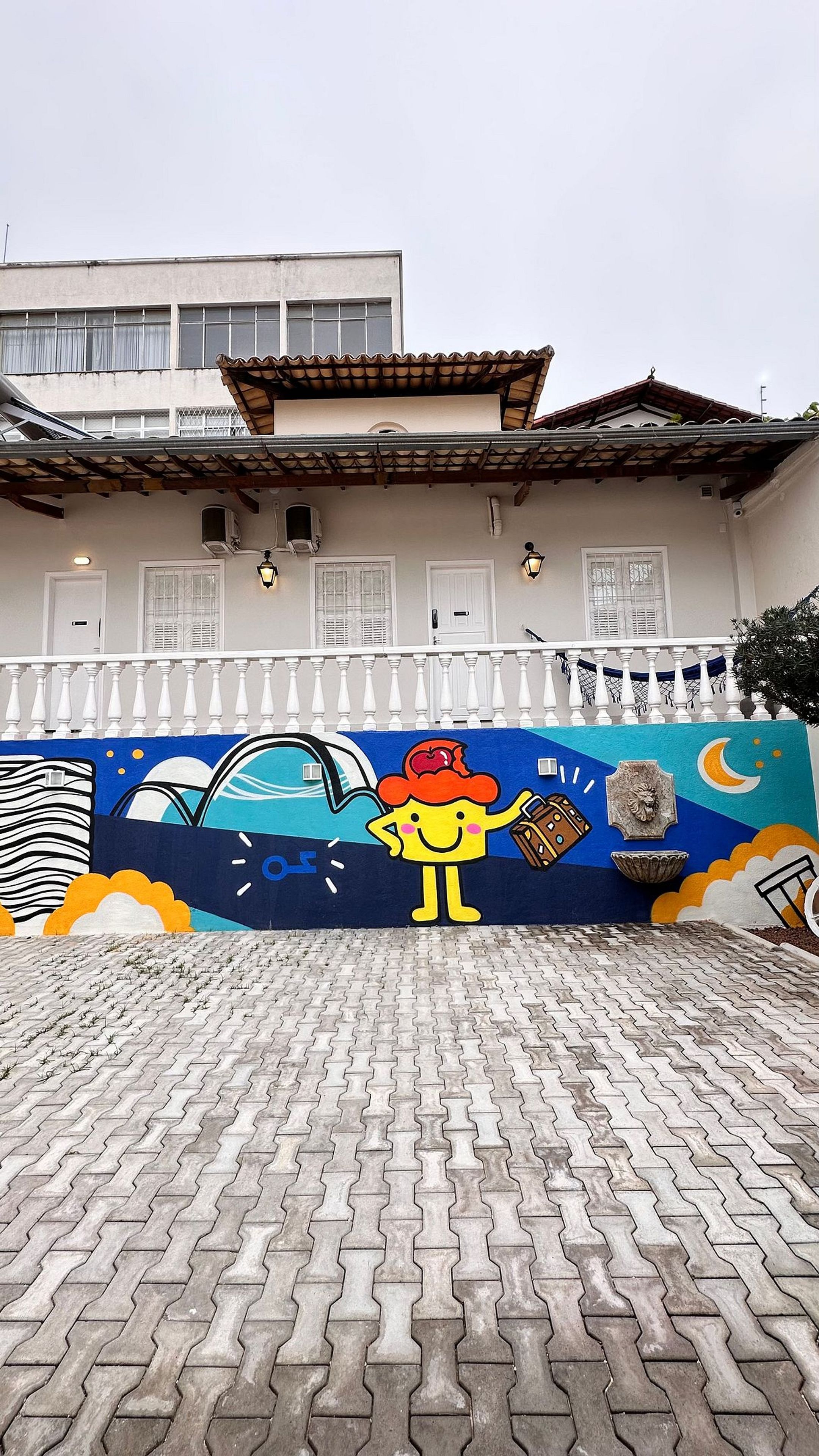 A building with a tiled roof and a mural on the wall depicting a cartoon character.