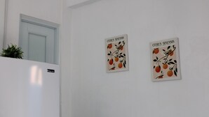 A kitchen with a white refrigerator and two wall-mounted signs with citrus fruit designs. - Live near the Colosseum! Apartment less than 20 min from the airport (San Juan)