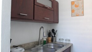 A kitchen with two sinks, a microwave, and a cabinet above the sink. - Live near the Colosseum! Apartment less than 20 min from the airport (San Juan)