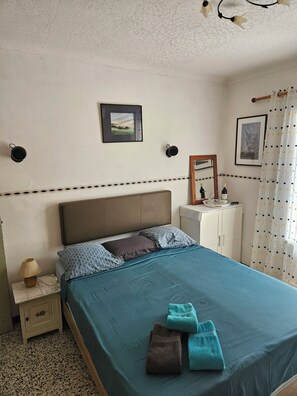A bedroom with a bed, a nightstand, a dresser, and a mirror. - Chambre 02 Balcon (Lézignan-Corbières)