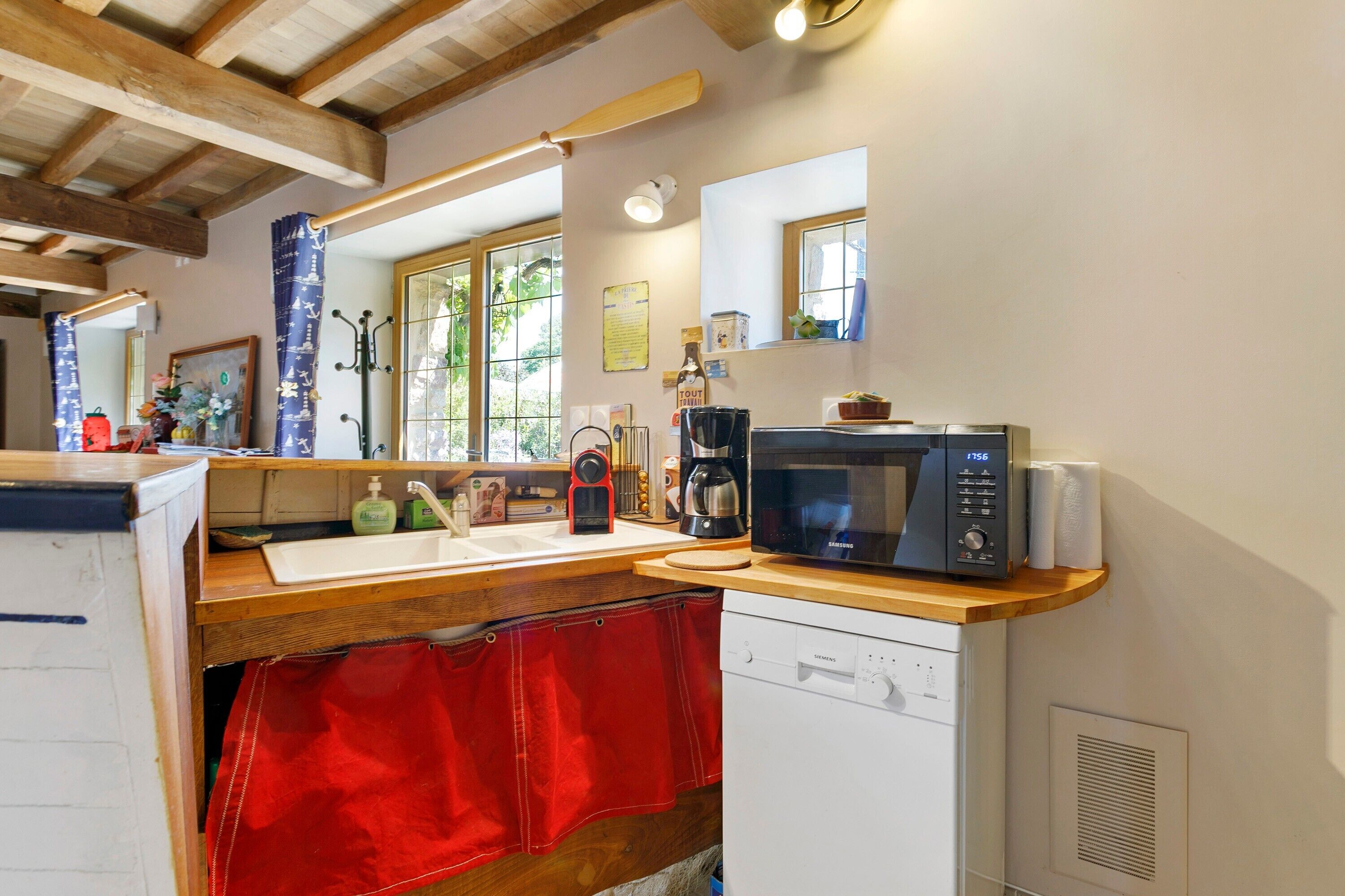 A kitchen with a microwave, coffee maker, and wooden counter.