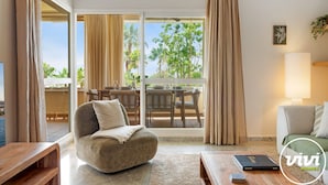 Ein modernes Wohnzimmer mit einer Couch, einem Couchtisch und einem Essbereich mit Tisch und Stühlen.