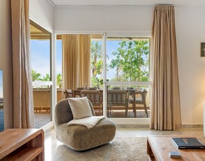 A modern living room with a sofa, a coffee table, and a dining area with a table and chairs.