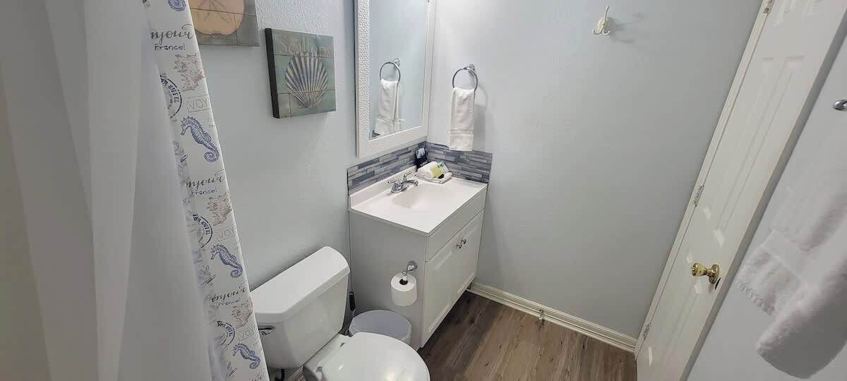 Une petite salle de bain avec des toilettes, un lavabo et un miroir.