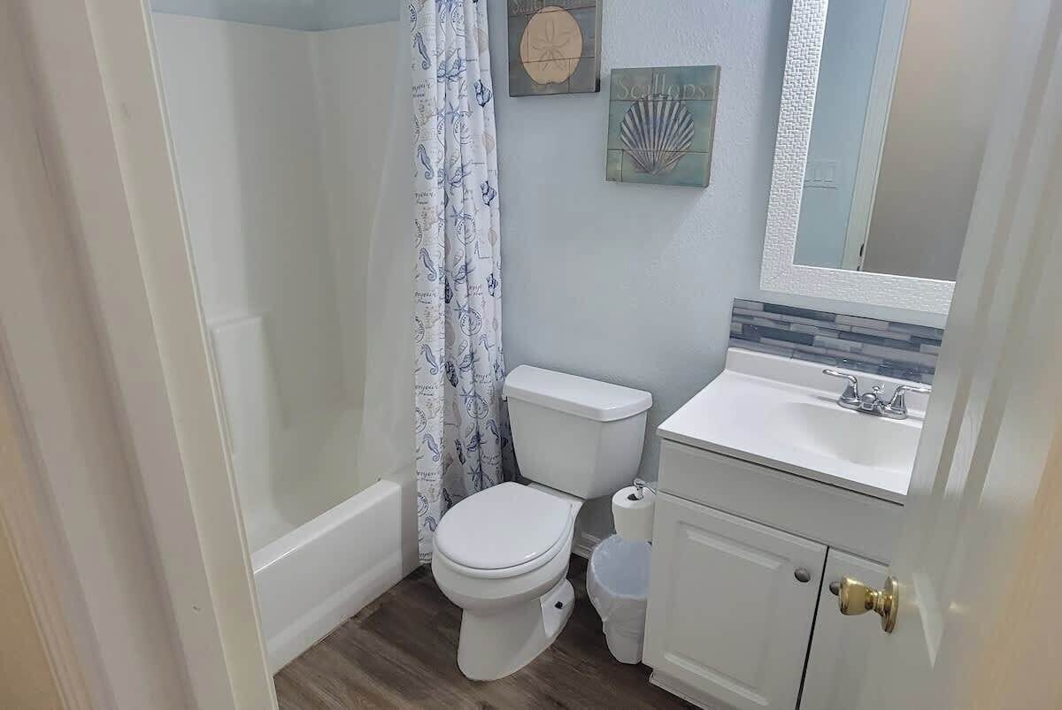 A bathroom with a toilet, sink, and shower.