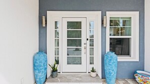 A front entrance with a double door, a window, and two large vases. - Mins Walk to Laguna Beach! King Suite, BBQ, Pool, Private Patio & Free parking (Panama City Beach)