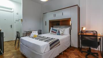 Ein Schlafzimmer mit Bett, Schreibtisch, Stuhl und Kleiderschrank.