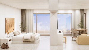 Habitació d'hotel moderna amb un llit gran, un sofà, zona de menjador i vista a la ciutat.